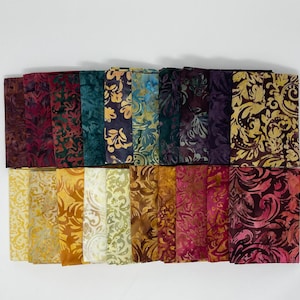May include: A collection of rectangular fabric swatches arranged in two rows, featuring batik-style patterns in a diverse color palette including deep purples, teals, golds, yellows, and pinks, with intricate swirling floral and leaf motifs.