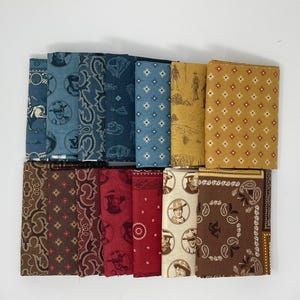 May include: A collection of folded bandanas in various colors and patterns. The bandanas feature designs such as paisley, cowboy illustrations, and geometric shapes. Colors include blue, red, brown, and yellow. The bandanas are arranged neatly on a white surface.