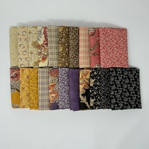 May include: A collection of folded fabric squares in various patterns and colors. The fabrics include floral, plaid, and solid designs in shades of yellow, red, brown, purple, and black. The squares are neatly stacked against a white background.