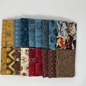 May include: A collection of folded fabric squares with various Western-themed patterns. Designs include cowboys, horses, cacti, and paisley in shades of blue, brown, red, and tan. The fabric appears to be cotton.