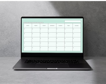 May include: A black laptop displays a monthly calendar template with a light green background. The calendar grid is composed of white boxes for each day, with the days of the week listed across the top. The laptop is on a gray surface.