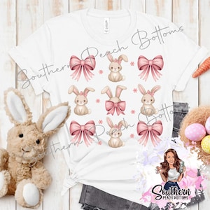 Puede incluir: Camiseta blanca con un diseño de conejo rosa y blanco con lazo. El texto "Southern Peach Bottoms" está impreso en la camiseta.