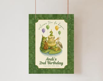 May include: A birthday sign with a green alligator playing a cello and a pelican next to a cake with a number 2 candle. The sign reads "welcome to da bayou" and "Andi's 2nd Birthday". The border is green.