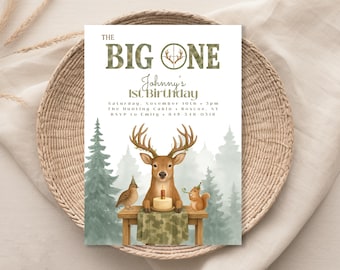 May include: A birthday invitation with a woodland theme. The text "THE BIG ONE" is at the top, with "Johnny's 1st Birthday" below. A deer, bird, and squirrel surround a cake. The background features trees and a camouflage pattern.