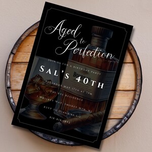 Peut inclure: Invitation noire et blanche avec une bordure dor&eacute;e. L'invitation indique "Vieilli &agrave; la perfection" et est pour la f&ecirc;te d'anniversaire de Sal pour ses 40 ans. L'invitation pr&eacute;sente une bouteille de bourbon et un verre de whisky.