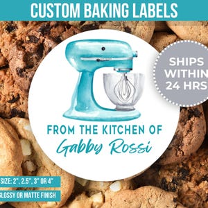 May include: A blue and white watercolour illustration of a stand mixer with the text "From the Kitchen of Gabby Rossi" on a round sticker. The sticker is surrounded by cookies.