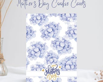 May include: A white card with a blue watercolor floral pattern and the text "Happy Mother's Day" in gold lettering.