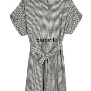 May include: A gray and white gingham-patterned dress with short sleeves and a matching belt. The dress has a button-up front and the text "Elabelle" is printed on the front.