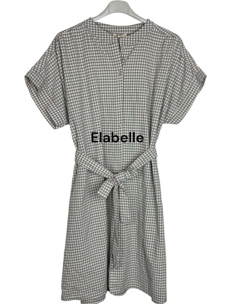 May include: A gray and white gingham-patterned dress with short sleeves and a matching belt. The dress has a button-up front and the text "Elabelle" is printed on the front.
