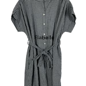 May include: A black and white gingham dress with short sleeves and a button-down front. The dress features a matching belt tied at the waist and the word "Elabelle" printed on the front.