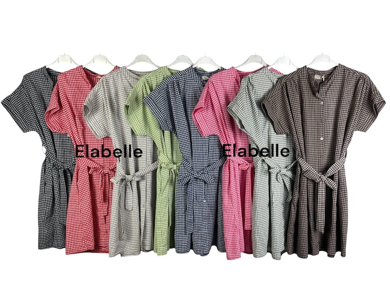 May include: A collection of short-sleeved dresses in various colors, including black, red, gray, green, blue, pink, and brown. Each dress features a gingham pattern, a matching belt, and the word "Elabelle" printed on the front.