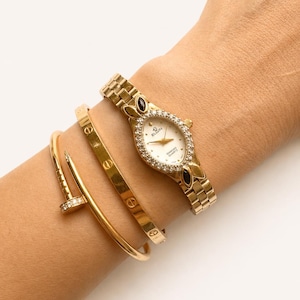 Orologio da donna ELGIN "The Heiress" anni '90 con quadrante ovale marquise in onice e diamanti, movimento al quarzo color oro.