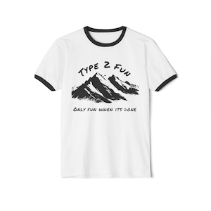 May include: White t-shirt with a black ringer neck. The shirt has a black graphic of mountains with the text "Type 2 Fun" and "Only Fun When It's Done" printed on it.