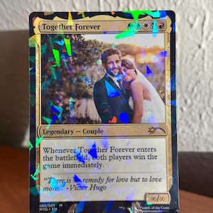 K&ouml;nnte beinhalten: Eine individuelle Sammelkarte mit dem Titel Together Forever und einer Gem-Foil-Oberfl&auml;che. Die Karte zeigt ein Foto eines Paares in Hochzeitskleidung, den Text Legendary - Couple und das Zitat There is no remedy for love but to love more von Victor Hugo.