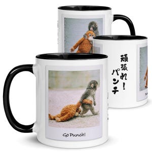 Puede incluir: Taza de cerámica blanca con asa y borde negros. La taza presenta una fotografía de un mono y un mono de peluche. El texto "Go Punch!" está impreso en la parte inferior de la foto.