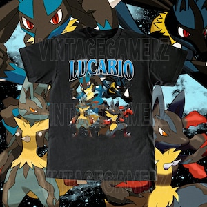 May include: Black t-shirt featuring a graphic of Lucario characters in various poses. The word "LUCARIO" is printed in blue and white. The background includes additional Lucario illustrations.