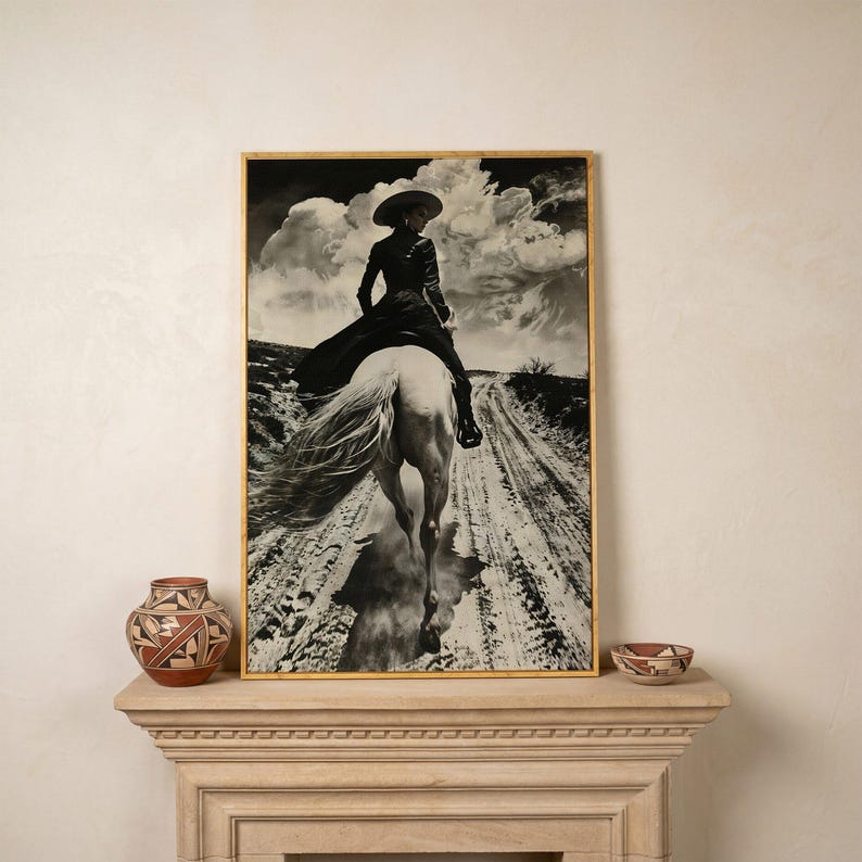 May include: Black and white framed print of a person riding a white horse on a dirt road. The person wears a hat and long coat. The sky is filled with dramatic clouds. Decorative pottery sits on a stone mantel.