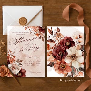 Könnte beinhalten: Hochzeitseinladungs-Set mit floralem Design in Burgunder-, Creme- und Pfirsichtönen. Die Einladung enthält die Namen "Shannon und Wesley", Datum, Uhrzeit und Ort. Ein Umschlag mit Wachssiegel und ein Band sind ebenfalls vorhanden.