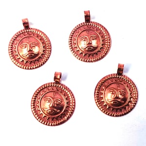 May include: Four copper-colored sun pendant charms. Each charm features a detailed sun face design within a circular frame with a loop at the top for attaching to a chain or cord. The pendants are on a white background.