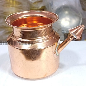 Puede incluir: Una olla neti de color cobre con un cuerpo redondeado, un borde ancho y un pico. La olla tiene un acabado brillante y parece estar hecha de metal. El texto "CraftByPanday" es visible en el lateral de la olla.