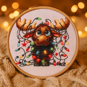 May include: A cross-stitch embroidery of a cartoon moose tangled in colorful Christmas lights. The moose has large blue eyes, brown fur, and large antlers. The embroidery is set in a wooden hoop, perfect for holiday decor.