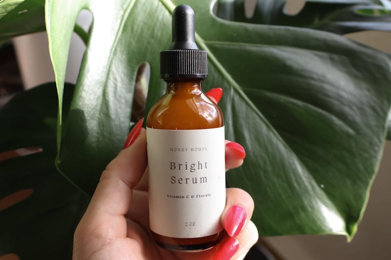 May include: A brown glass bottle with a dropper top, labeled "Honey House Bright Serum Vitamin C & Florals 2oz".