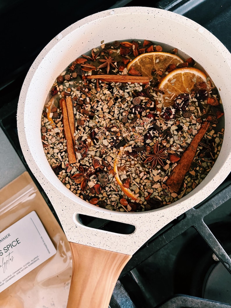 Simmer pot on stovetop with spices and citrus slices in water