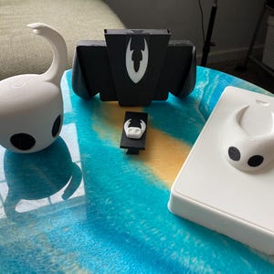 Puede incluir: Un juego de tres tazas de cerámica con un acabado moteado y mate. Las tazas son de color crema, gris claro y gris oscuro. Cada taza tiene un diseño simple y minimalista y un asa redondeada. Para café o té.