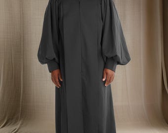 May include: A black cassock with a white collar. The cassock has long sleeves with large cuffs and a long, flowing skirt.