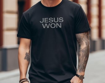 May include: Black t-shirt with the text "JESUS WON" in gray block letters. The short-sleeved shirt is made of a soft material. The shirt is a casual wear item.