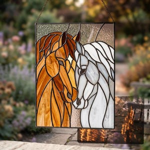 May include: A rectangular stained glass panel featuring two horse heads facing each other. One horse is rendered in warm amber and brown glass tones, while the other is crafted from white and translucent glass, all held together by dark metal cames.