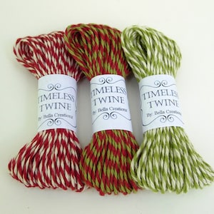 Pu&ograve; includere: Tre rotoli di spago, ognuno con una diversa combinazione di colori: rosso e bianco, verde e bianco e rosso e verde. Ogni rotolo ha un'etichetta con la scritta "TIMELESS TWINE" e sotto il testo "By: Bella Creations".