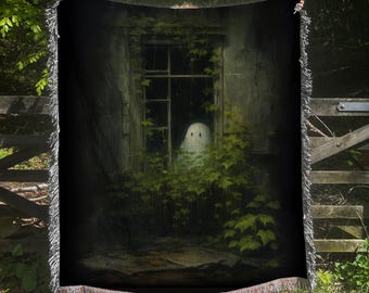 Puede incluir: Una manta tejida negra con un diseño de fantasma espeluznante. La imagen muestra un fantasma en una ventana rodeado de vegetación. La manta tiene un borde con flecos y se exhibe al aire libre.