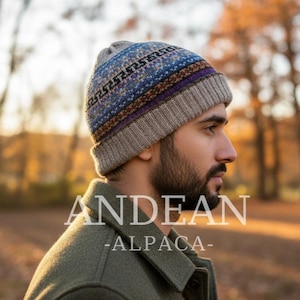 Può includere: Un berretto lavorato a maglia con un motivo geometrico blu, viola e marrone. Il cappello è realizzato in un materiale morbido e caldo, perfetto per il freddo. Il testo "ANDEAN ALPACA" è visualizzato in bianco.