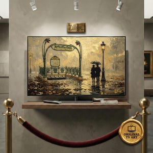 Può includere: Una stampa d'arte digitale su uno schermo TV raffigura una scena parigina piovosa con un'insegna "METROPOLITAIN". L'opera d'arte presenta una coppia sotto un ombrello, un lampione e foglie autunnali. L'arte è esposta su una mensola di legno.