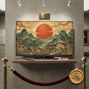 Può includere: Un grande televisore a schermo piatto mostra un dipinto di paesaggio con un sole arancione, montagne verdi e dettagli floreali. La TV è su una mensola di legno con un telecomando e materiali artistici.
