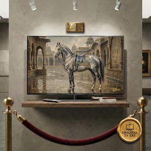 Pode incluir: Uma impressão de arte digital exibida em uma TV de tela plana. A obra de arte retrata um cavalo cinzento com uma sela azul em um cenário de pátio. A TV é montada em uma prateleira de madeira com um controle remoto e um pincel. A imagem é rotulada como "Original TV Art".