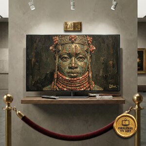 Puede incluir: Un televisor de pantalla plana grande que muestra un retrato detallado de una persona con un tocado y un collar de cuentas. La obra de arte es en tonos verdes, marrones y naranjas. El televisor está en una estantería de madera.