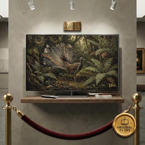 Può includere: Un grande televisore a schermo piatto mostra un dipinto dettagliato di un uccello con una lunga coda ornata, ambientato in una foresta lussureggiante. L'opera d'arte presenta sfumature di verde, marrone e oro. La TV è montata su una mensola di legno.