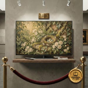 Può includere: Un grande schermo televisivo rettangolare mostra una scena naturalistica con un nido di uccelli, uova e fiori bianchi. Il televisore è montato su una mensola di legno con un telecomando e materiali artistici. L'immagine è etichettata "Original TV Art".