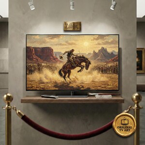 Puede incluir: Pintura digital de una escena de rodeo mostrada en una pantalla de televisión. La obra representa a un vaquero montando un caballo salvaje en un paisaje desértico. El televisor está montado en una estantería de madera.