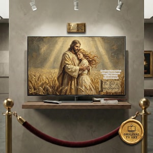 Puede incluir: Una gran pantalla de televisión muestra una pintura religiosa de dos figuras abrazándose en un campo de trigo. La obra de arte presenta tonos cálidos y el texto "The Lord is my Shepherd". El televisor está montado en una estantería de madera.