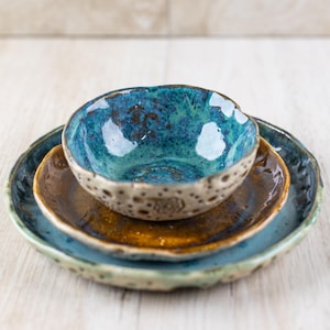 Può includere: Una tazza di ceramica bianca con manico nero e la scritta "But First, Coffee" in nero, con un carattere a mano. La tazza è su una superficie bianca.