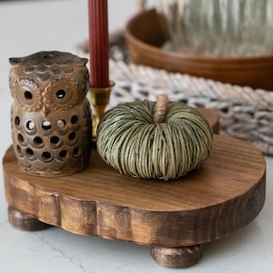 May include: A decorative wooden tray with a brown finish, featuring a ceramic owl figurine, a green pumpkin, and a burgundy candle. The tray has a rustic, natural aesthetic, perfect for fall decor.