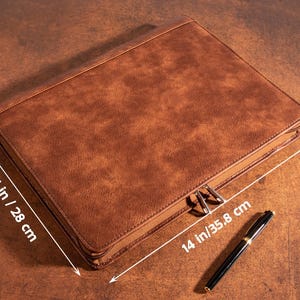 May include: A brown leather zippered portfolio with measurements of 11 inches by 14 inches and 1.57 inches in height.