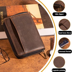 May include: A brown leather wallet with a black zipper, external pocket, and hand-sewn thread. The wallet is displayed on a wooden surface next to a book. The text "Silk Zipper", "Hand Sewn Thread", "External Pocket", and "Exquisite printing" are visible.