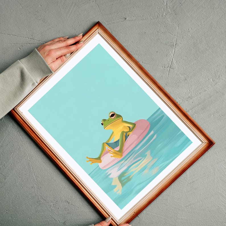 May include: A green frog wearing blue shorts sits on a pink inflatable ring in a blue pool. The frog is looking to the right of the image.