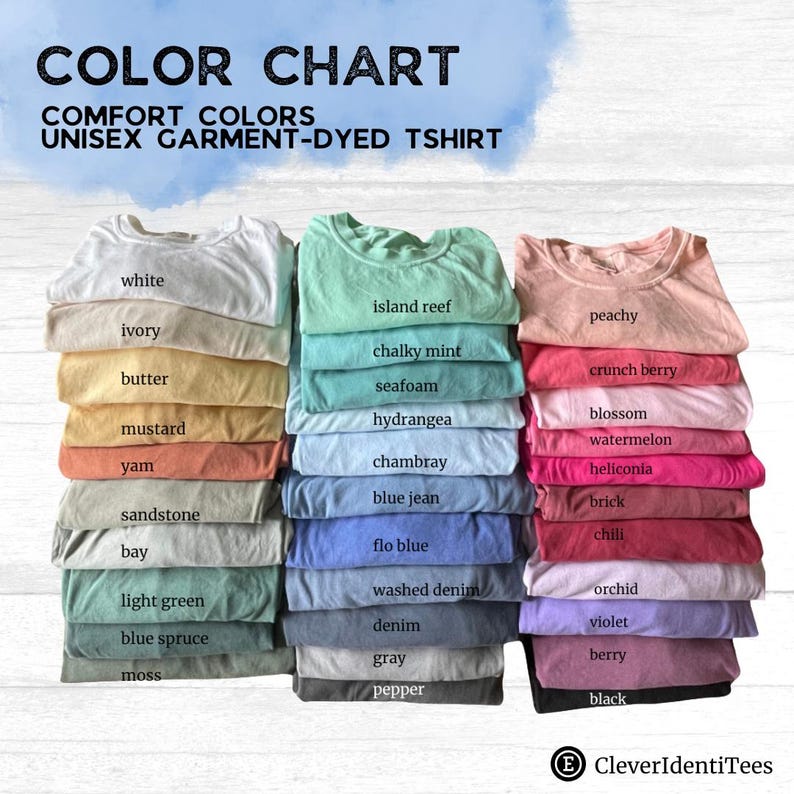 May include: A color chart for Comfort Colors unisex garment-dyed t-shirts featuring three vertical stacks of folded shirts in various shades. Text labels identify colors including white, ivory, butter, mustard, yam, sandstone, bay, light green, blue spruce, moss, island reef, chalky mint, seafoam, hydrangea, chambray, blue jean, flo blue, washed denim, denim, gray, pepper, peachy, crunch berry, blossom, watermelon, heliconia, brick, chili, orchid, violet, berry, and black.