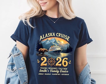 May include: A navy blue t-shirt featuring a graphic of a cruise ship, a bear, and mountains. The text reads ALASKA CRUISE 2026, MAKING MEMORIES TOGETHER, SMITH'S FAMILY CRUISE, and the locations JUNEAU, SKAGWAY, GLACIER BAY, KETCHIKAN.