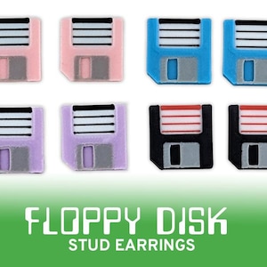 Könnte beinhalten: Acht bunte Floppy-Disk-Ohrstecker in Rosa, Blau, Lila und Schwarz. Jeder Ohrring hat ein rechteckiges Design mit weißen und grauen Details. Der Text "FLOPPY DISK STUD EARRINGS" ist darunter abgebildet.